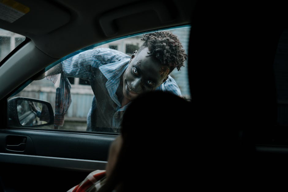 haunted attractions and Halloween theme parks - Frightening zombie peering through a car window during a horror scene.