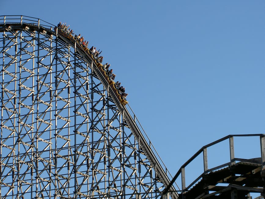 roller coaster g-forces - Experience the exhilarating thrill of a roller coaster ascending the steep peak at an amusement park.