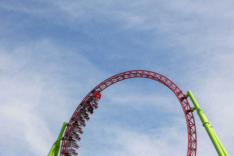 roller coaster g-forces - An exciting roller coaster performing a loop under a clear blue sky, capturing thrill and exhilaration.