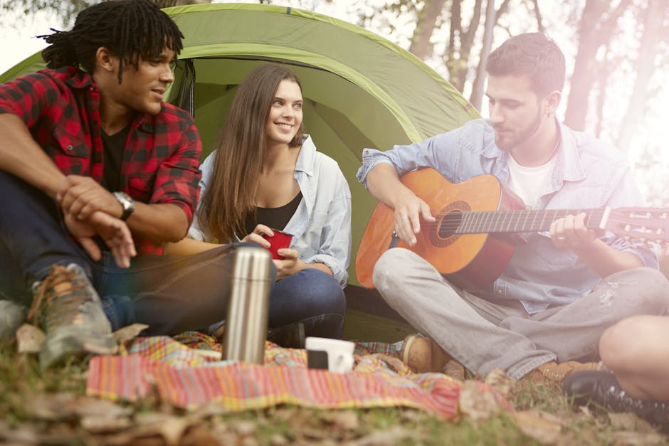music festival packing list - A group of young friends enjoying a summer camping trip with music and relaxation outdoors.