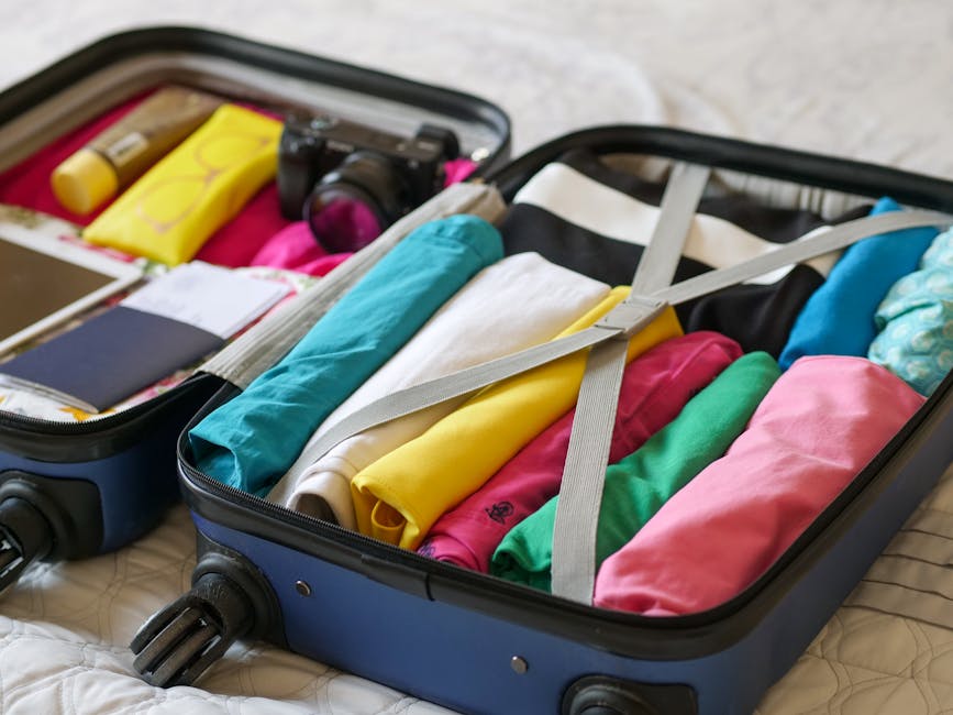 music festival packing list - Open suitcase neatly packed with colorful clothes and travel essentials.