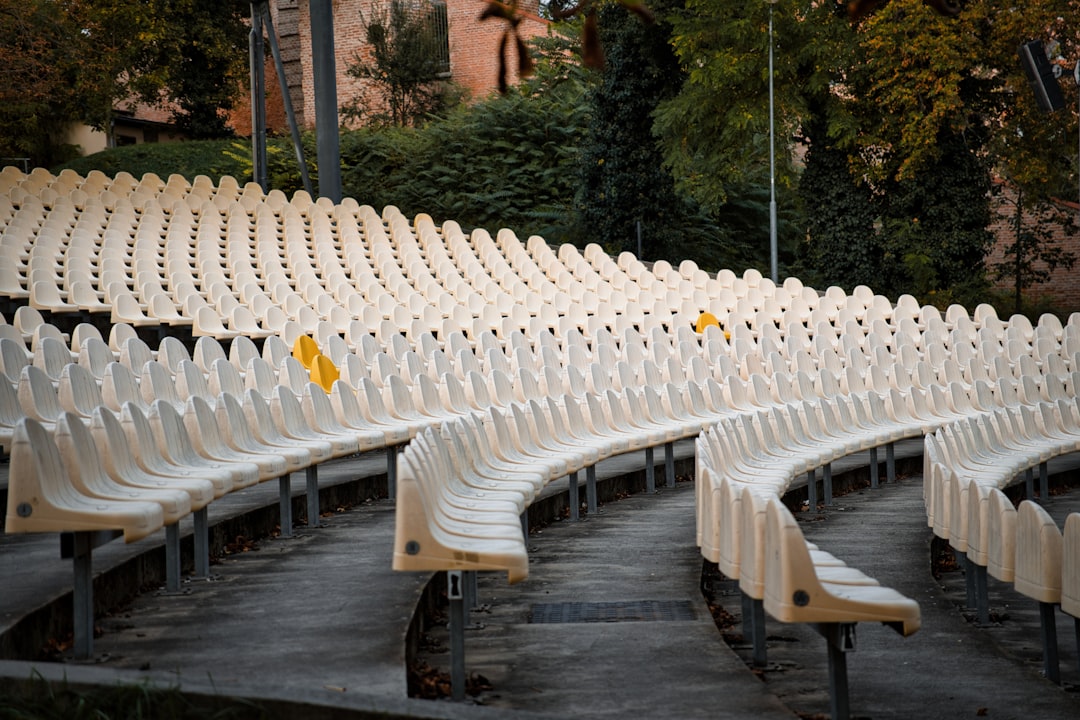 types of concert venues - Empty outdoor amphitheater seating with trees in background