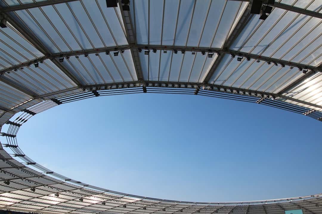 types of sporting stadiums - Clear blue sky seen through stadium roof opening.