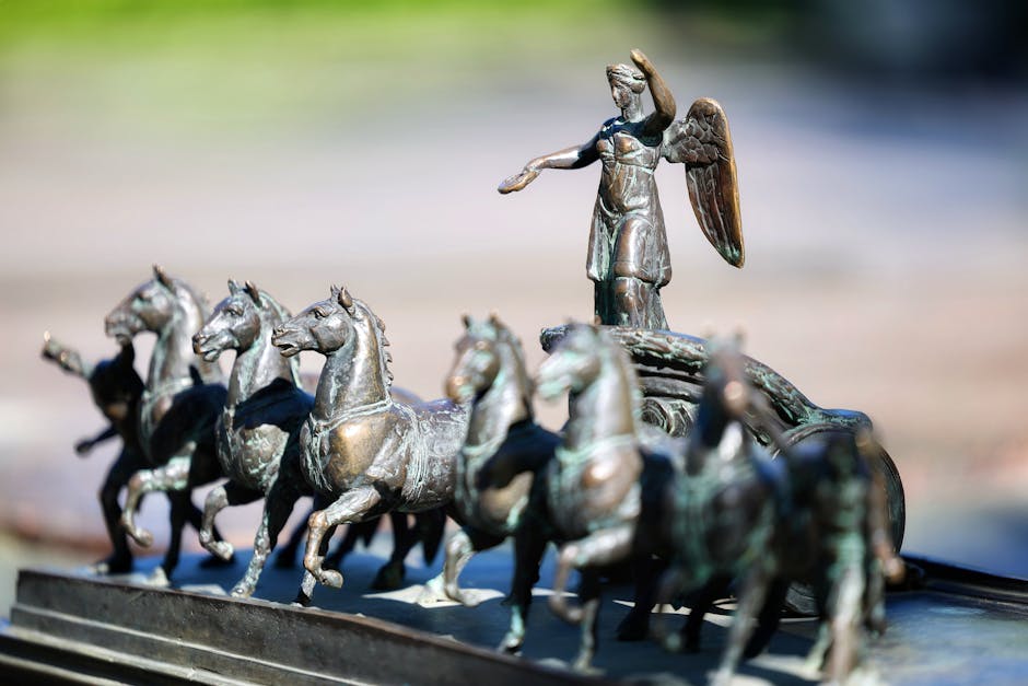 busch gardens williamsburg - Detailed bronze sculpture of angel on chariot with horses, outdoor setting.