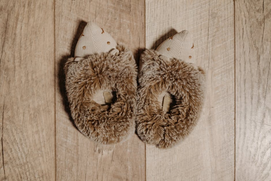 hypercoaster category - Top view of cute and cozy furry slippers placed on a wooden surface, perfect for warmth and comfort.
