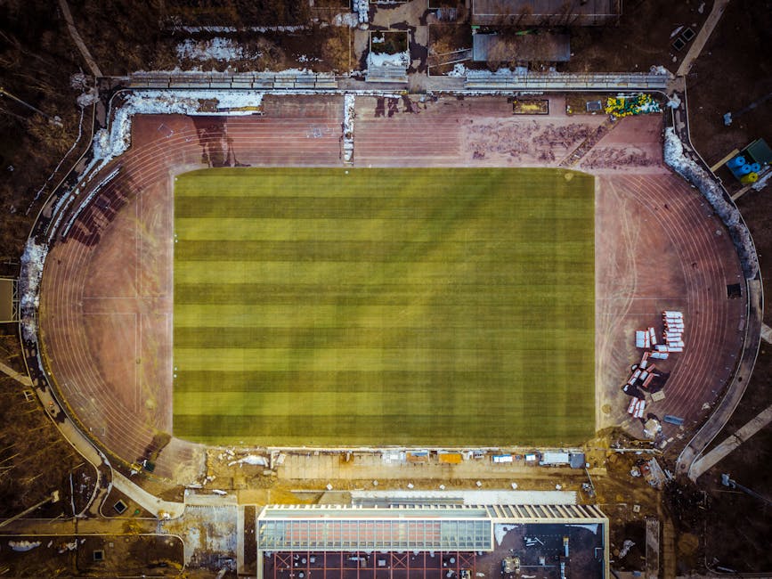 top nfl stadiums - Aerial photograph of an empty sports stadium with clear field and track.