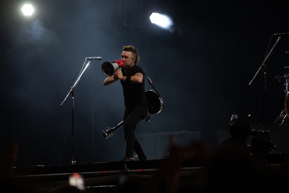 lollapalooza festival - Musician with megaphone on stage during night concert, energizing the crowd.
