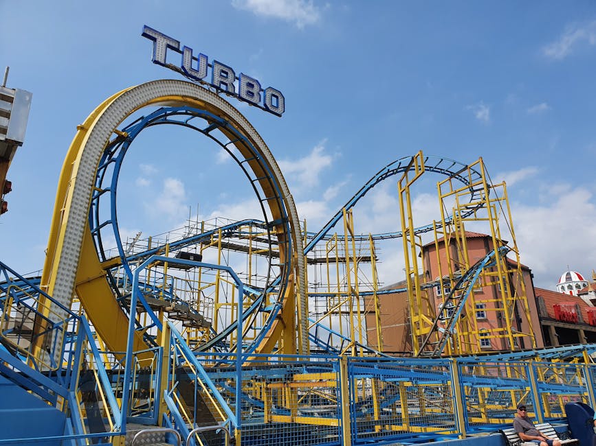 six flags magic mountain - Dynamic view of a colorful roller coaster against a clear blue sky.