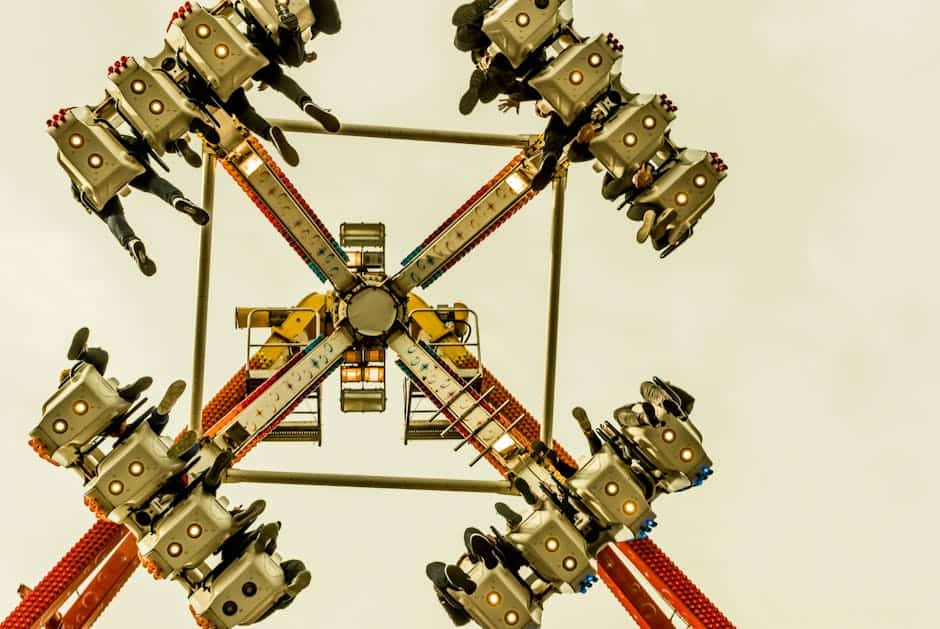 theme park news May 2026 - Exciting perspective of a spinning amusement park ride captured from below, highlighting fun and adventure.