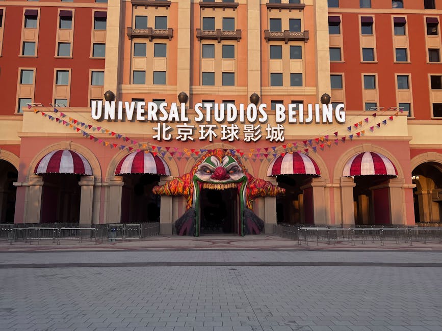 theme park news May 2026 - Entrance to Universal Studios Beijing with vibrant clown-themed decor and festive flags.