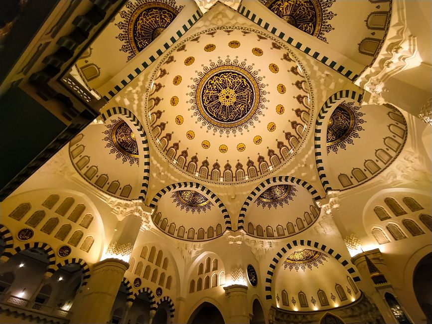 sports venues - Stunning low angle shot of an ornate mosque ceiling with intricate golden and navy designs.