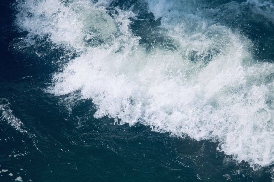 theme park news - Vibrant ocean wave crashing with frothy foam on the deep blue sea surface, conveying energy and movement.
