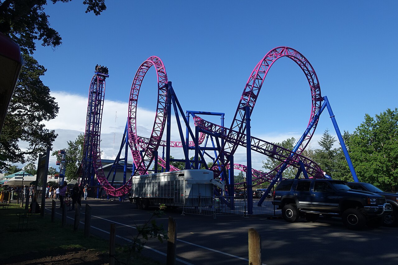 Full daytime view of Adrenaline Peak's magenta track, vertical lift and loop at Oaks Amusement Park