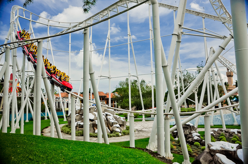 Avalancha roller coaster train descending a drop between white track supports at Xetulul, Guatemala
