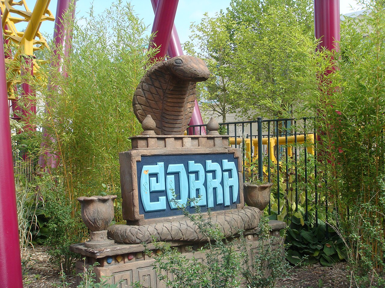 Carved cobra statue and ride sign at the entrance to Cobra at Walibi Belgium