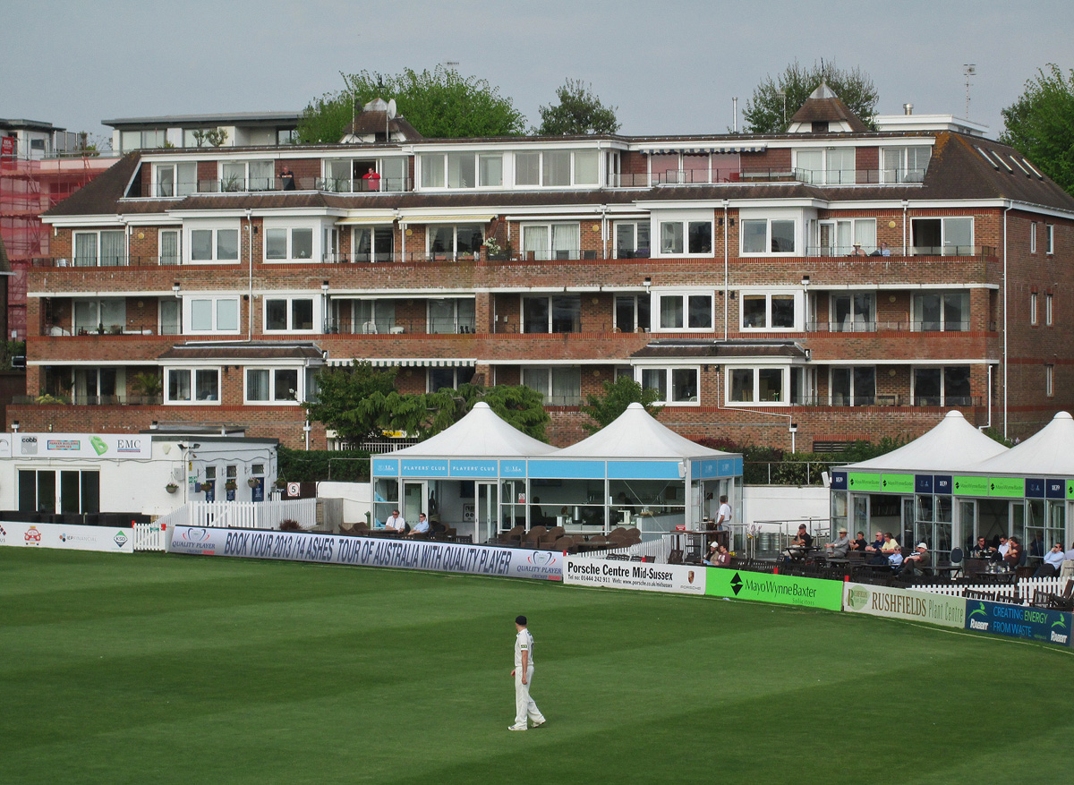 Fielder on the boundary at Hove with apartment blocks behind