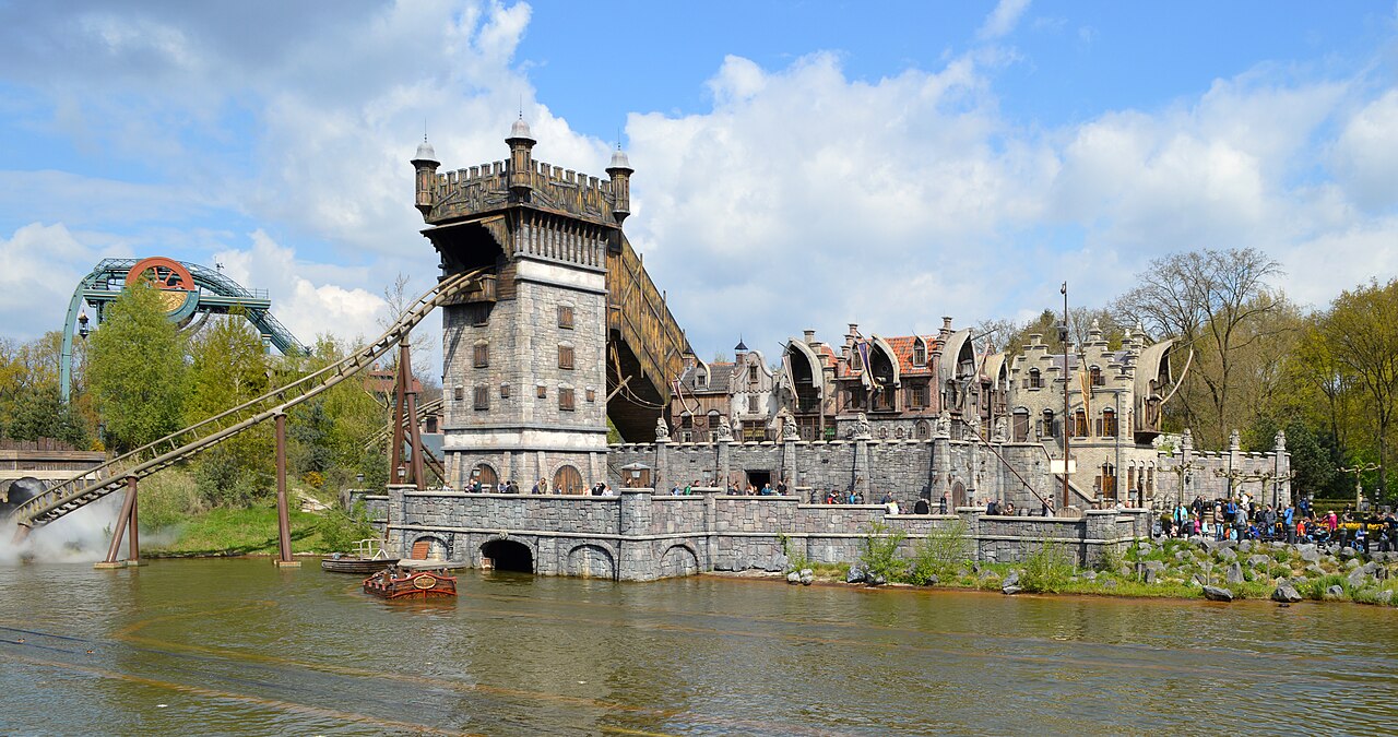 De Vliegende Hollander's harbor buildings and coaster drop seen from across the pond at Efteling