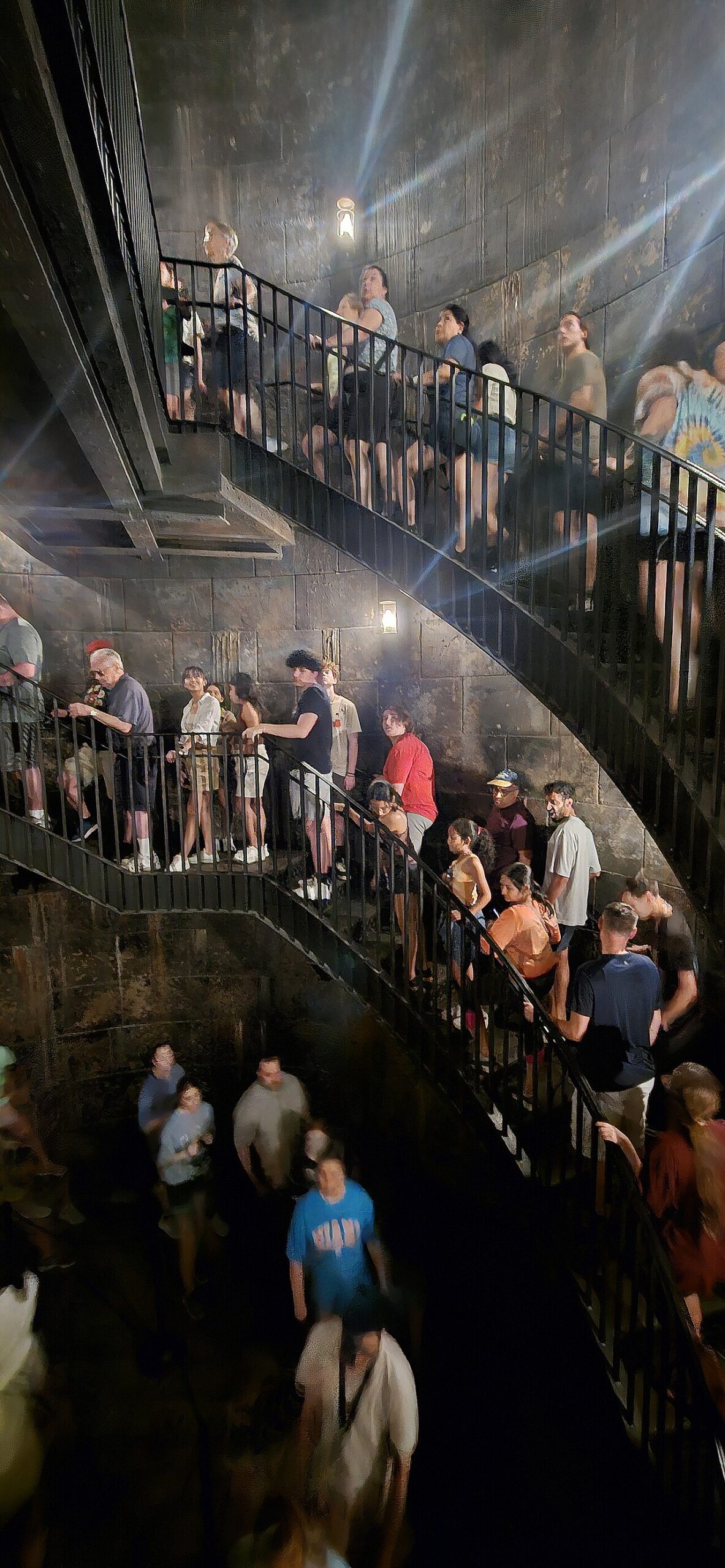 Guests descending the stone spiral staircase in the Escape from Gringotts queue at Universal Studios Florida