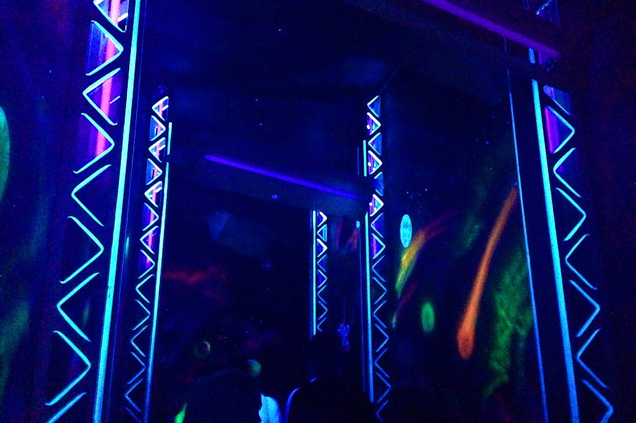 Blacklight-lit indoor queue of Euro-Mir at Europa-Park with glowing geometric patterns