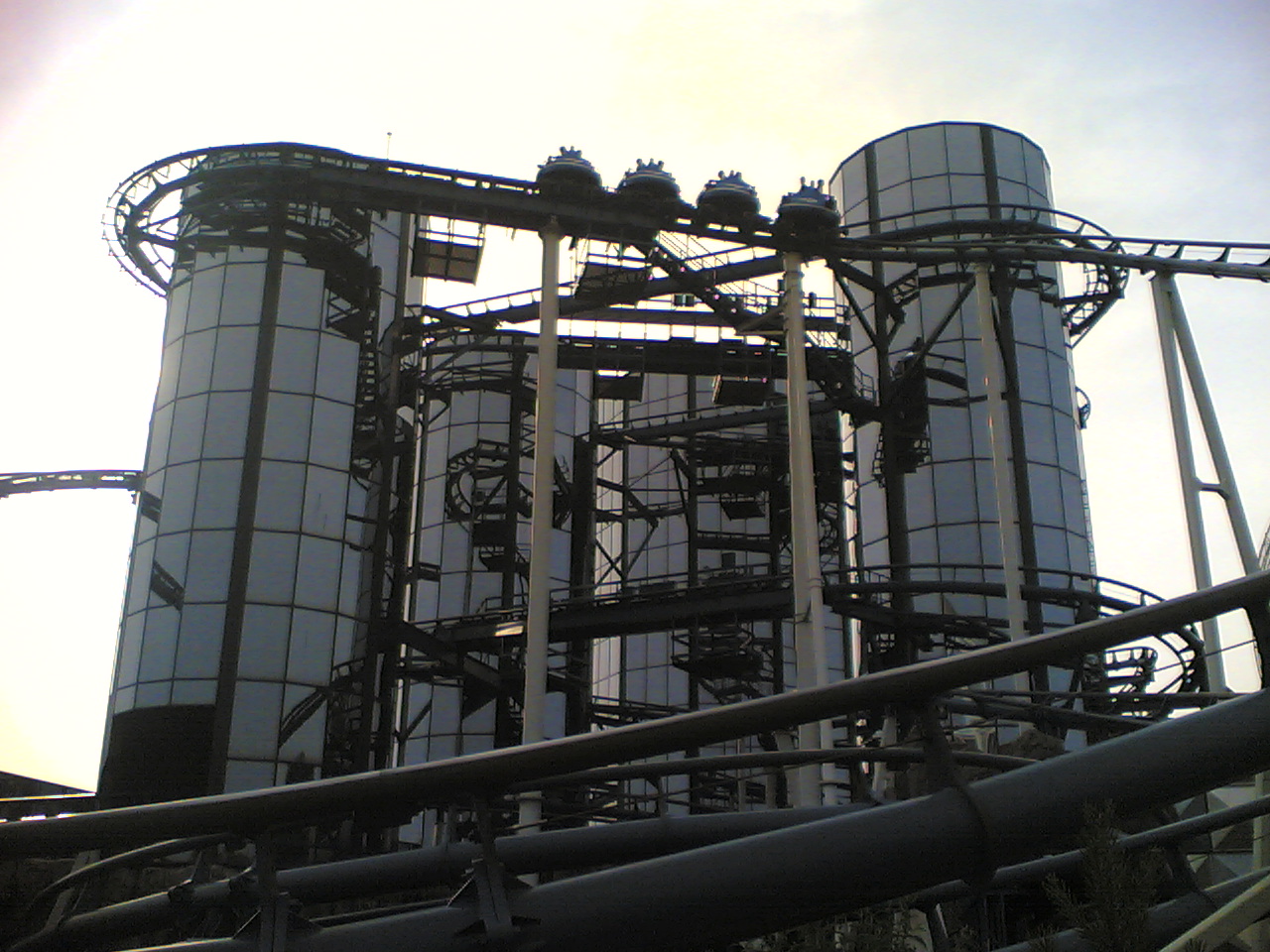 Silhouetted Euro-Mir spinning cars circling the tops of the mirrored towers at Europa-Park at dusk