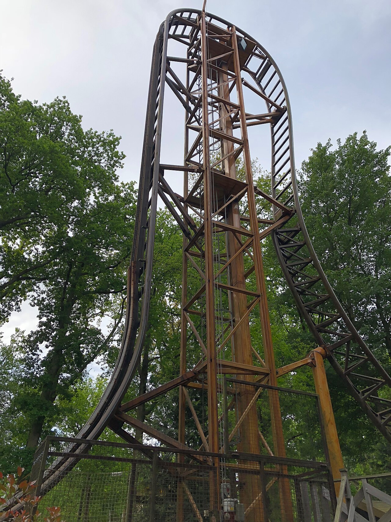 Falcon's vertical lift tower and beyond-vertical drop rising above the trees at Duinrell