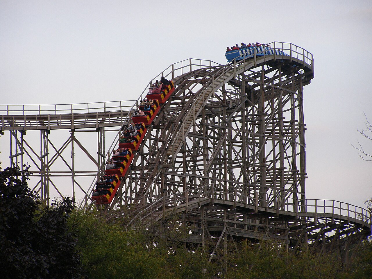 Gemini trains cresting a hill on the wooden structure at Cedar Point