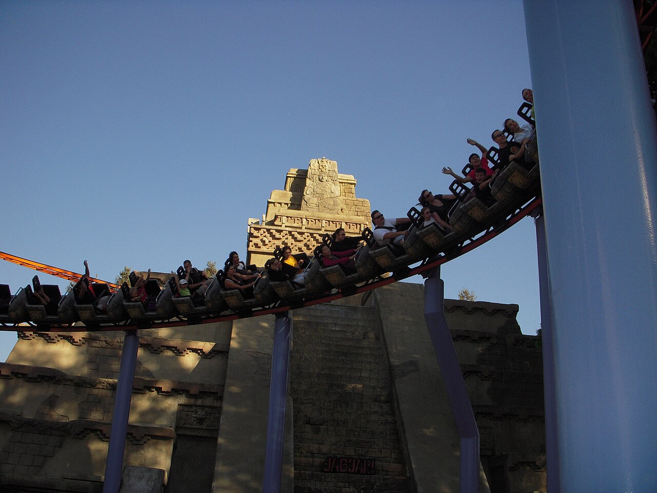Jaguar! train with riders rounding a bend past the temple at Knott's Berry Farm