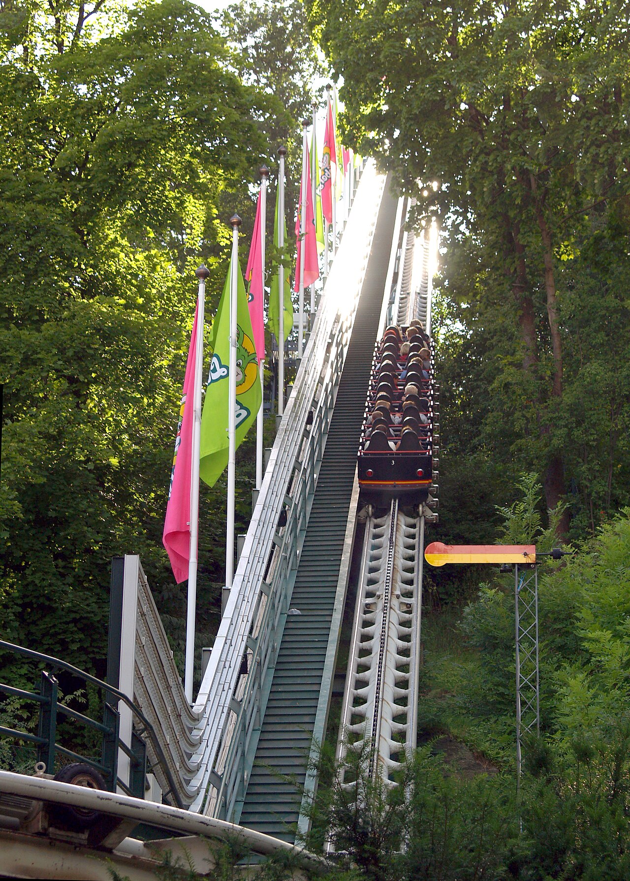 Lisebergbanan train climbing the flag-lined lift hill at Liseberg