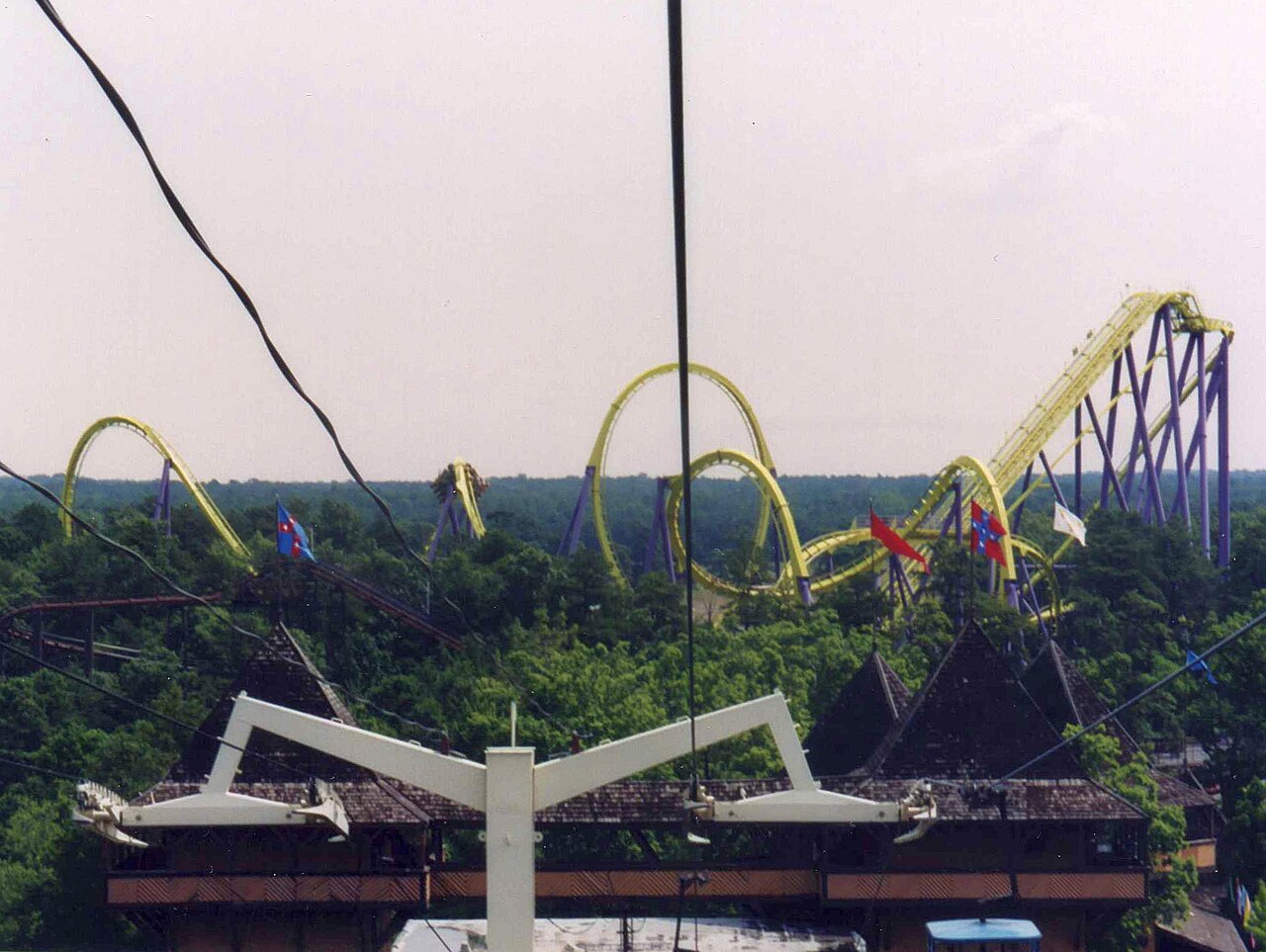 Medusa's original lime green track and purple supports rise above the trees at Six Flags Great Adventure