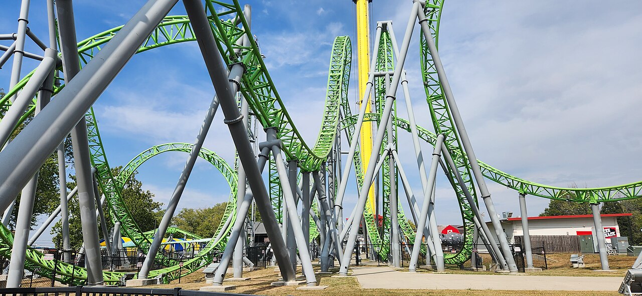 The Monster's lime-green track weaving through gray supports near the station at Adventureland