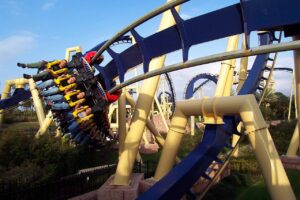 Riders' legs dangle as Montu's train swings through an inversion on blue track at Busch Gardens Tampa Bay