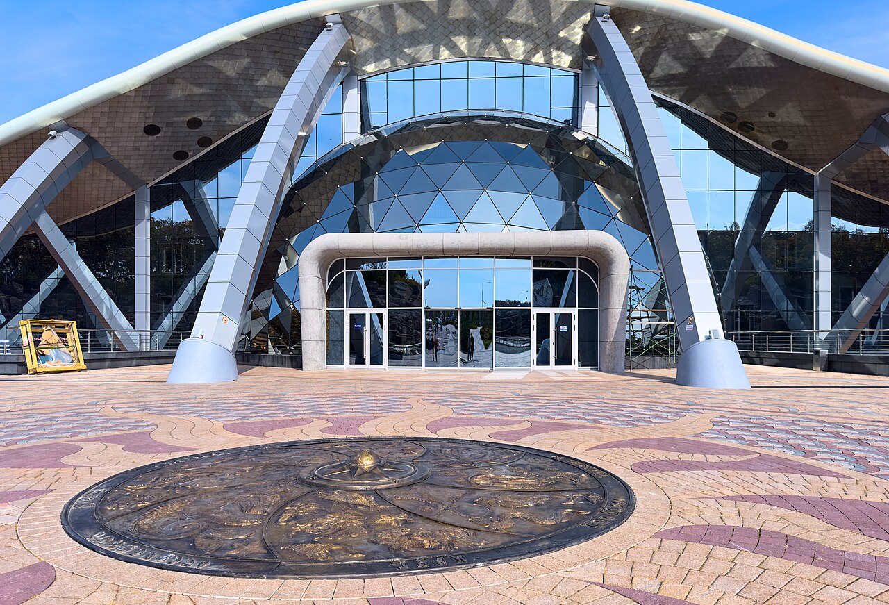 Main entrance of the Primorsky Oceanarium beneath its glass dome and sweeping white arches