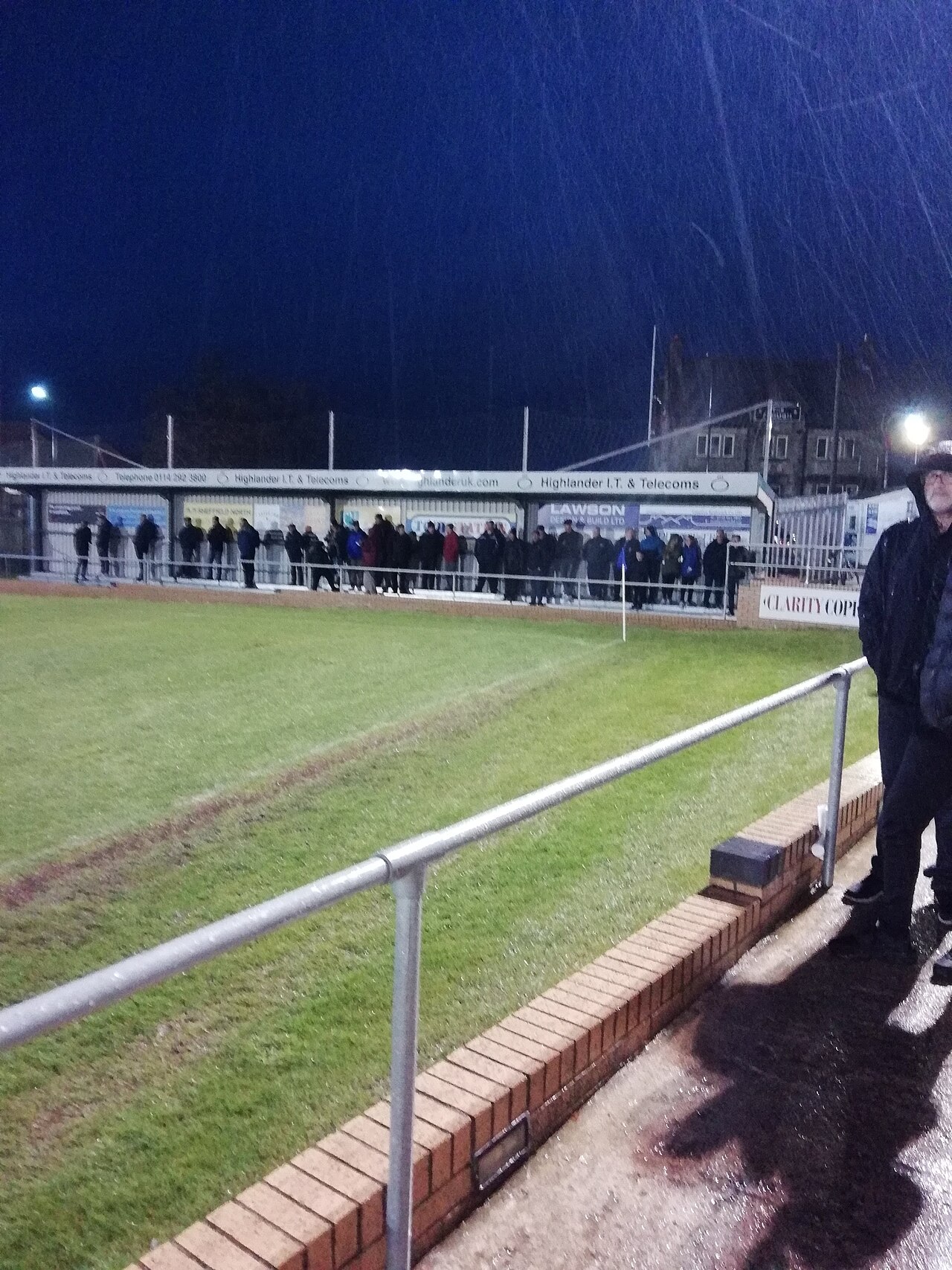 Covered terrace and supporters at Sandygate Road under lights