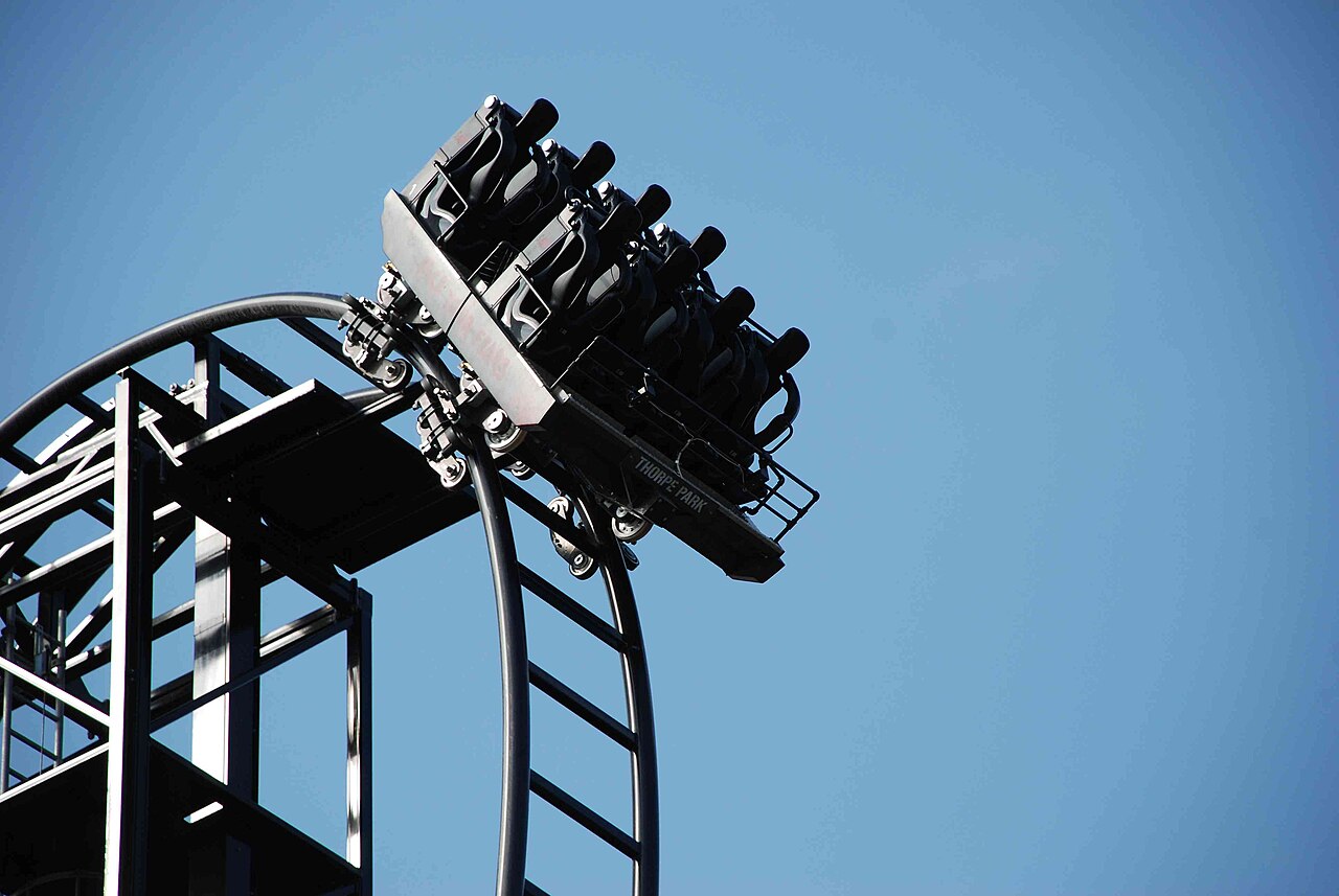 A Saw The Ride train tipping over the crest of the beyond-vertical drop at Thorpe Park