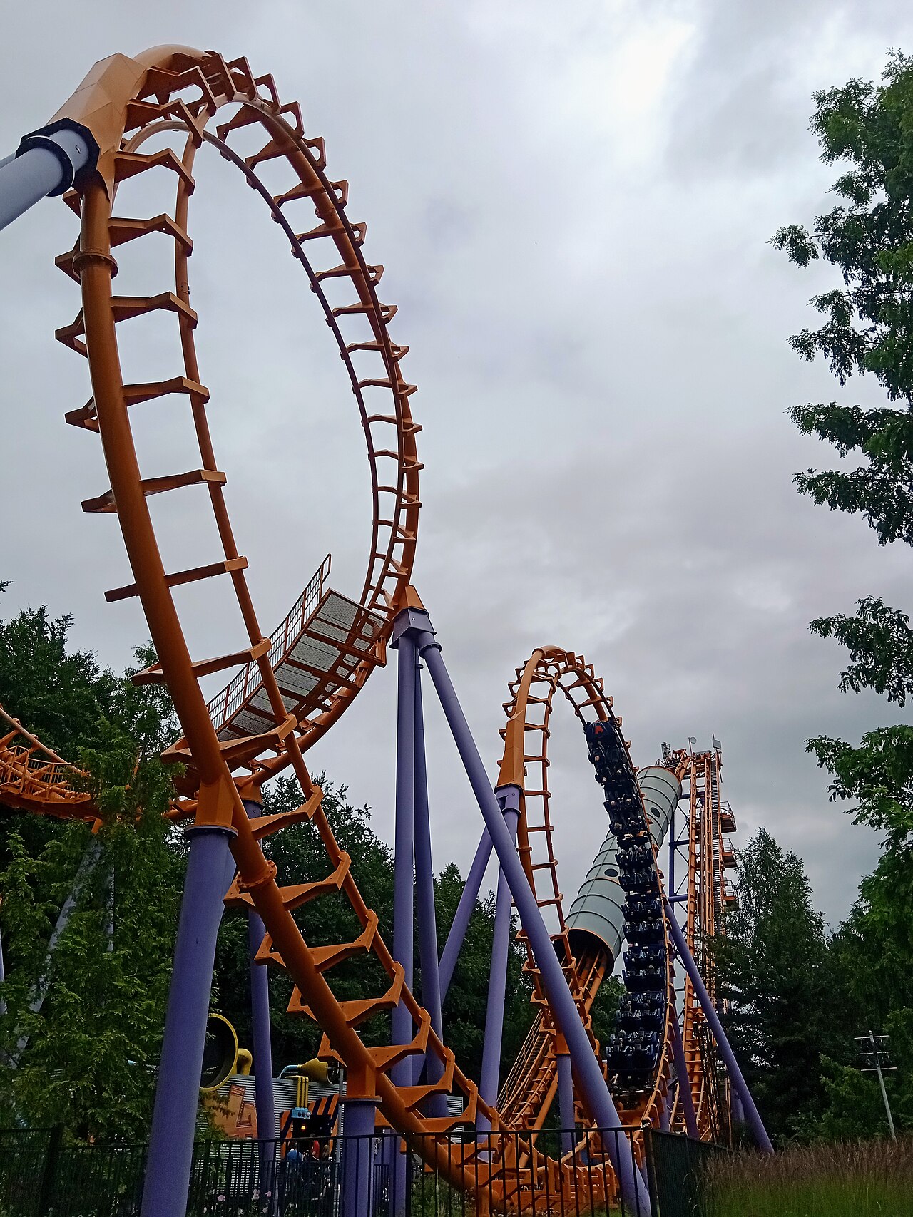 Looking up at the cobra roll of Speed of Sound as a train dives through at Walibi Holland