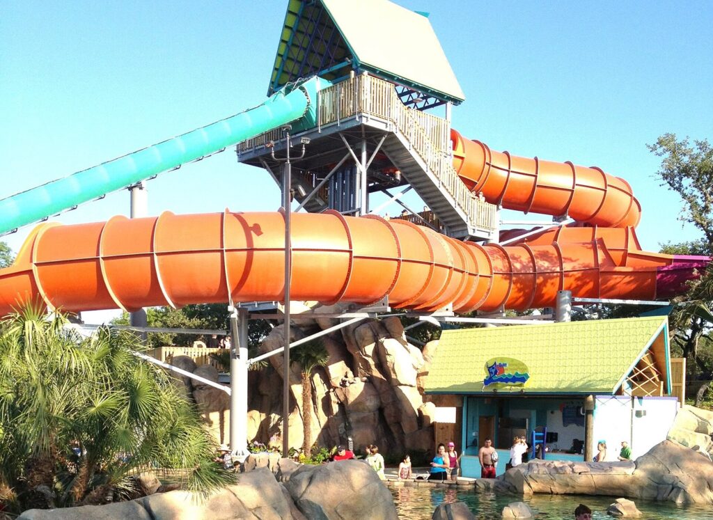 Tall water park slide tower feeding large orange tube slides, illustrating the kind of slide complex The Fractionator belongs to