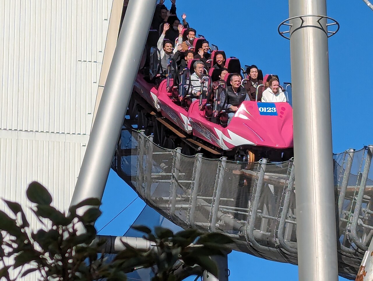 Riders aboard Thunder Dolphin's pink train at Tokyo Dome City