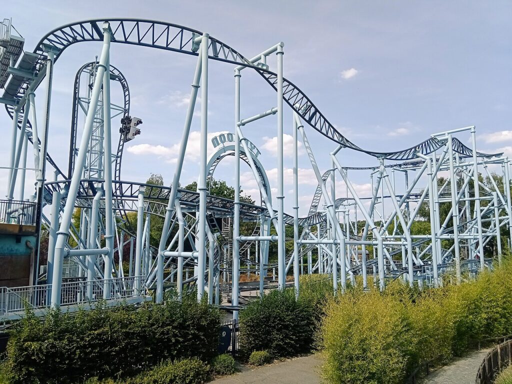 Typhoon roller coaster at Bobbejaanland, Belgium, with light blue supports and dark blue track, car descending the beyond-vertical drop