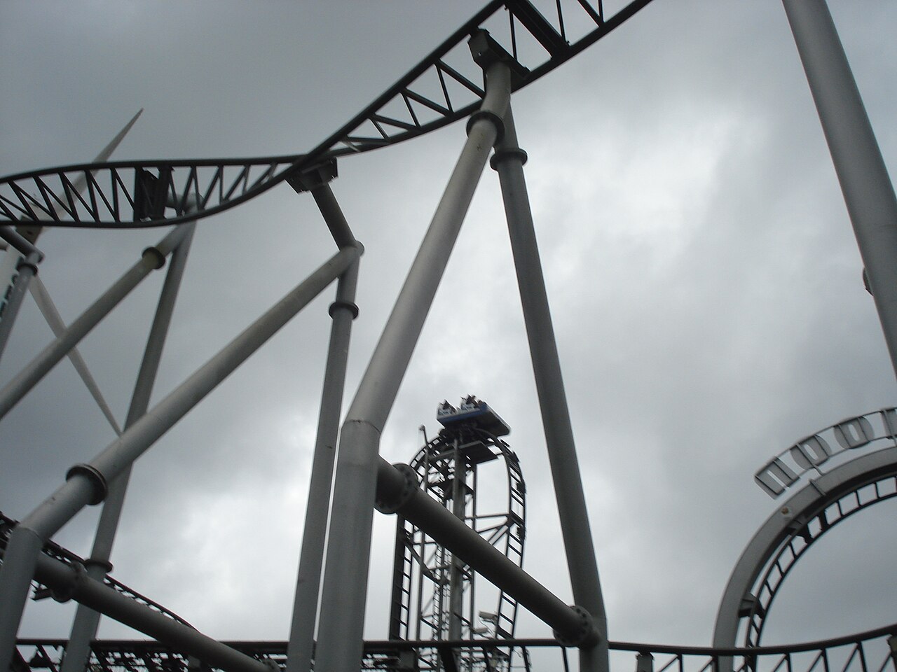 View up through Typhoon's track structure as a car crests the drop at Bobbejaanland