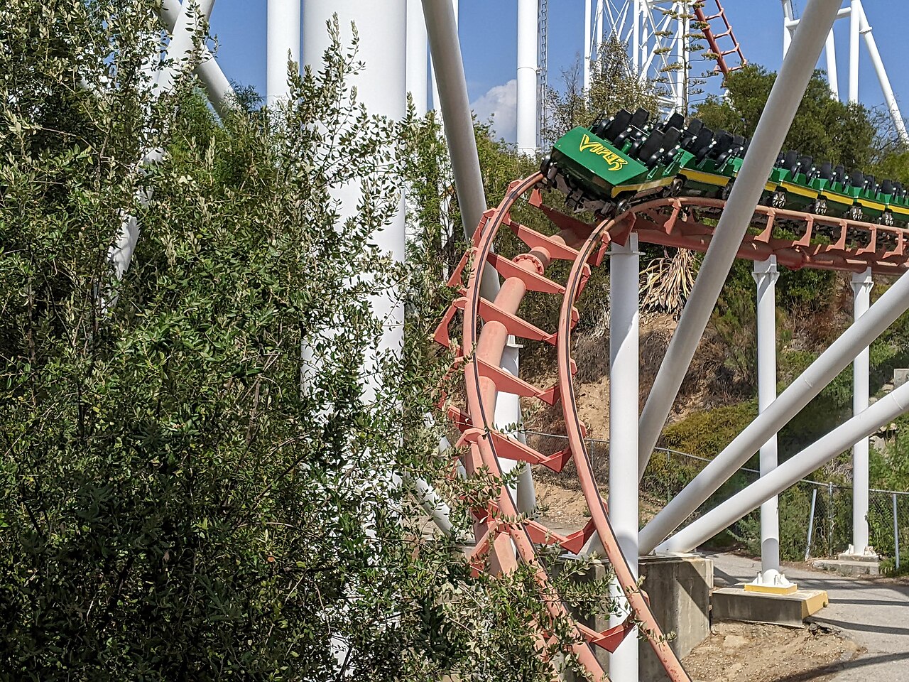Viper's green and yellow train dips through the corkscrew section between white supports