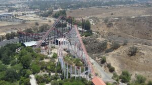 Aerial view of Viper's red track and white supports at Six Flags Magic Mountain with X2 in the background