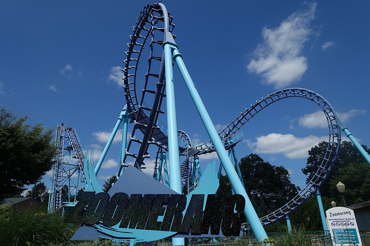 Zoomerang entrance sign with the sky-blue Boomerang layout and rear lift spike behind at Lake Compounce