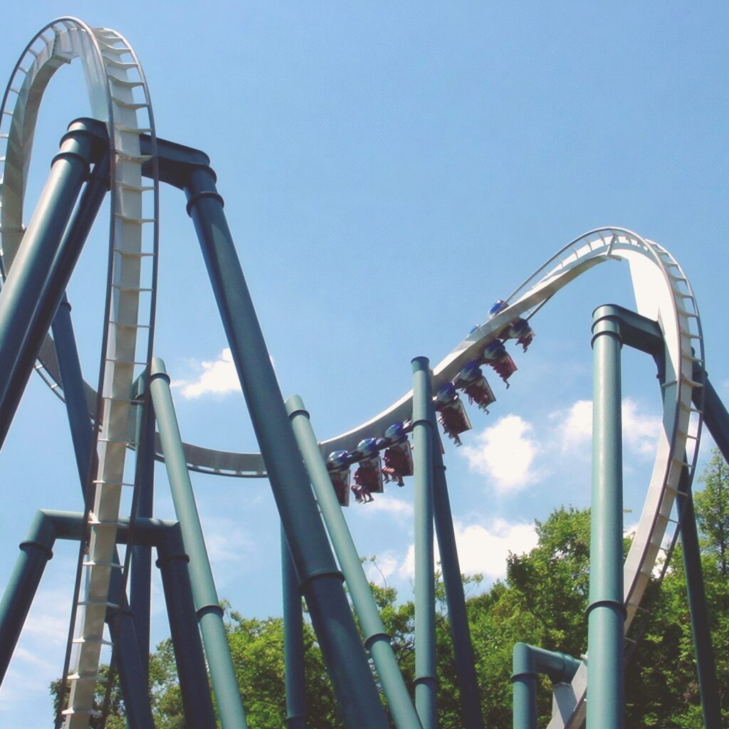 An Alpengeist train twisting through the cobra roll above its teal supports at Busch Gardens Williamsburg