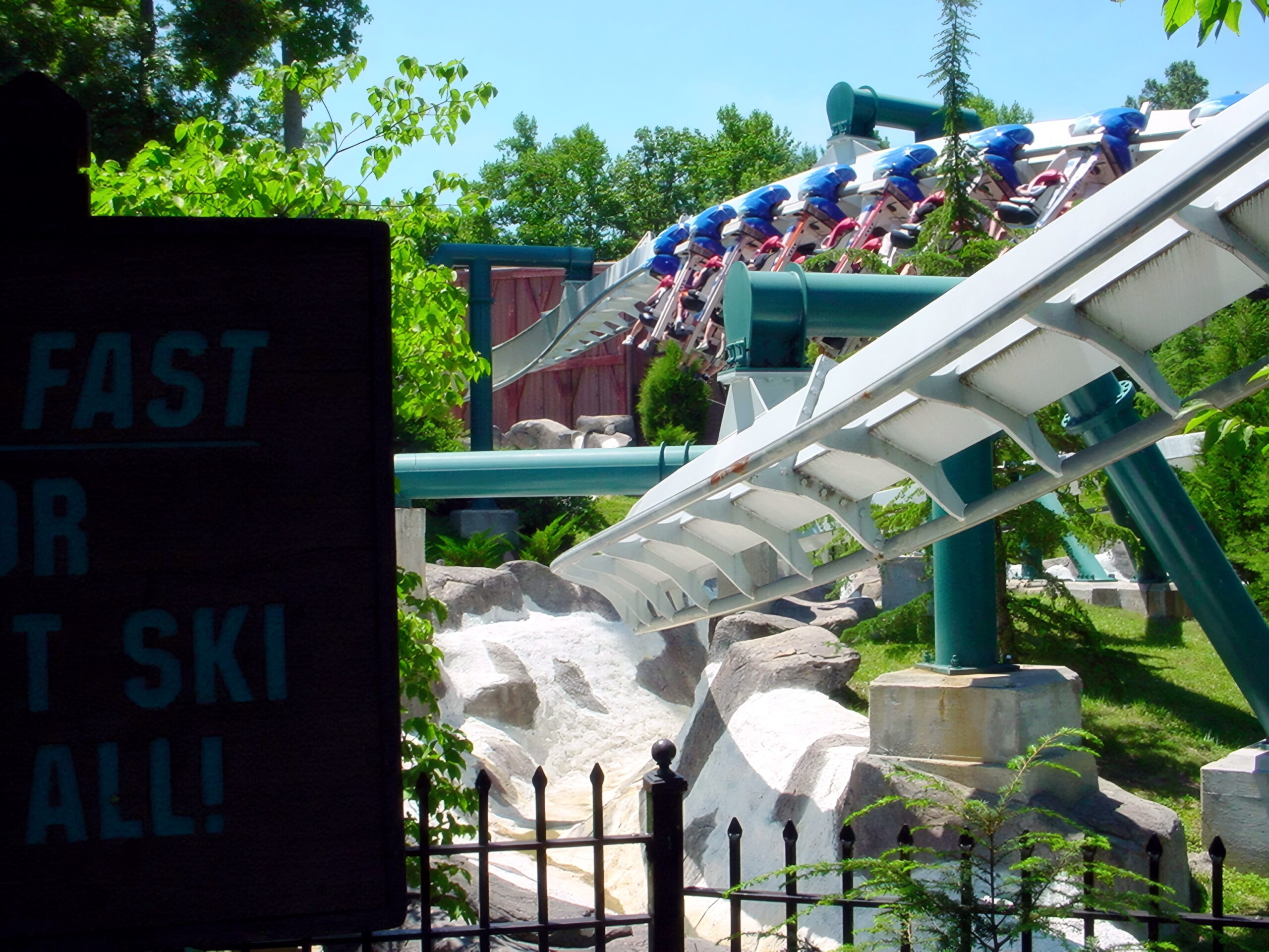 An Alpengeist train over the rock waterfall with riders' feet dangling, July 2001