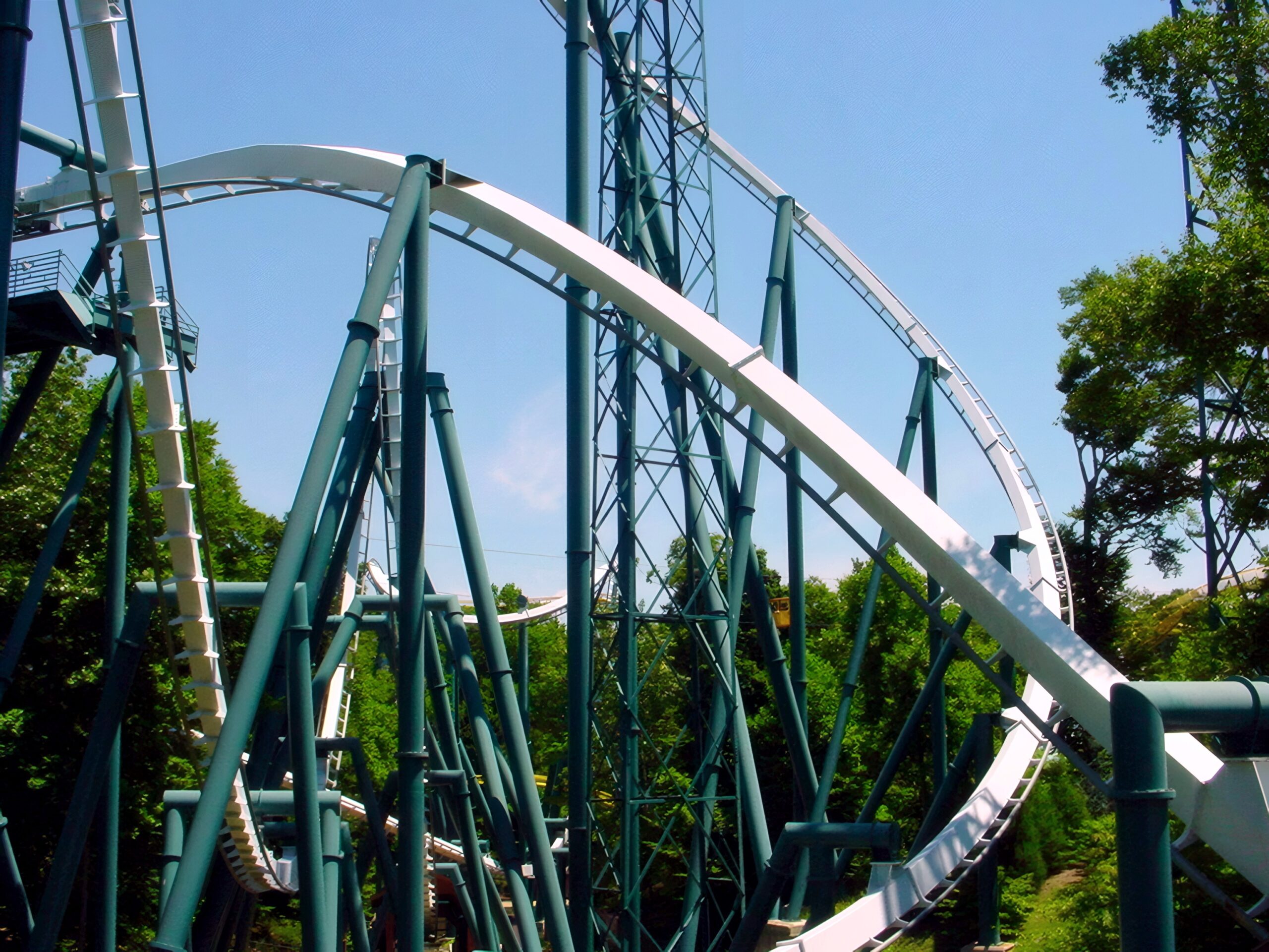 Alpengeist's twisting first drop sweeping down through its supports, with the layout beyond, July 2001