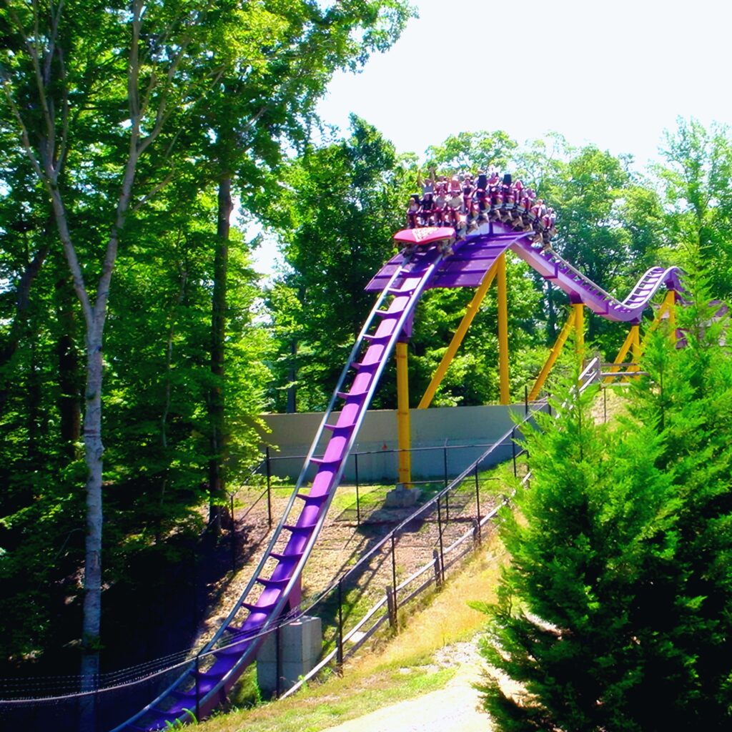 An Apollo's Chariot train cresting a hill above the trees at Busch Gardens Williamsburg