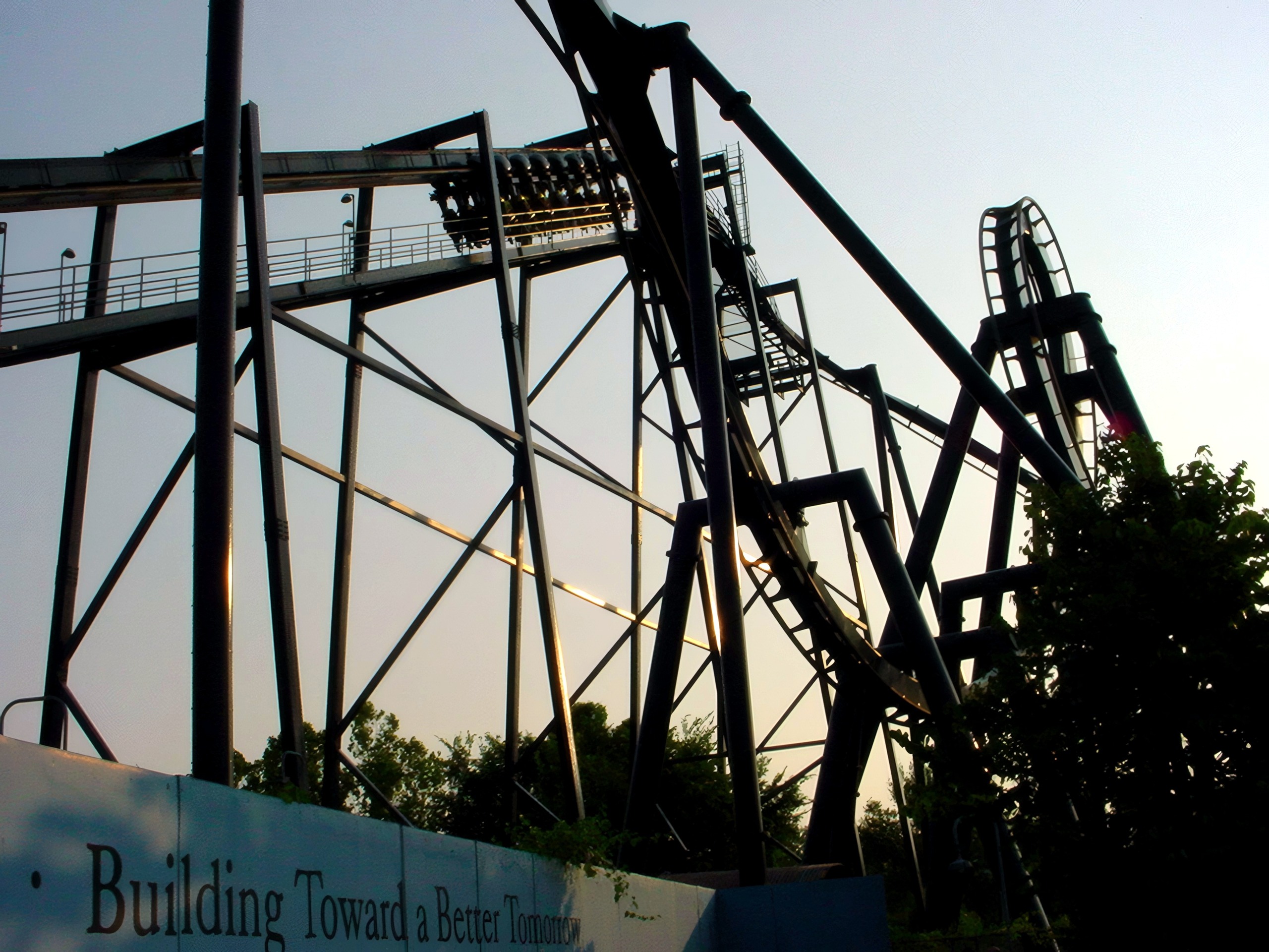 A Batman: The Ride train hanging beneath the track above the Gotham City wall at Six Flags St. Louis, June 2002