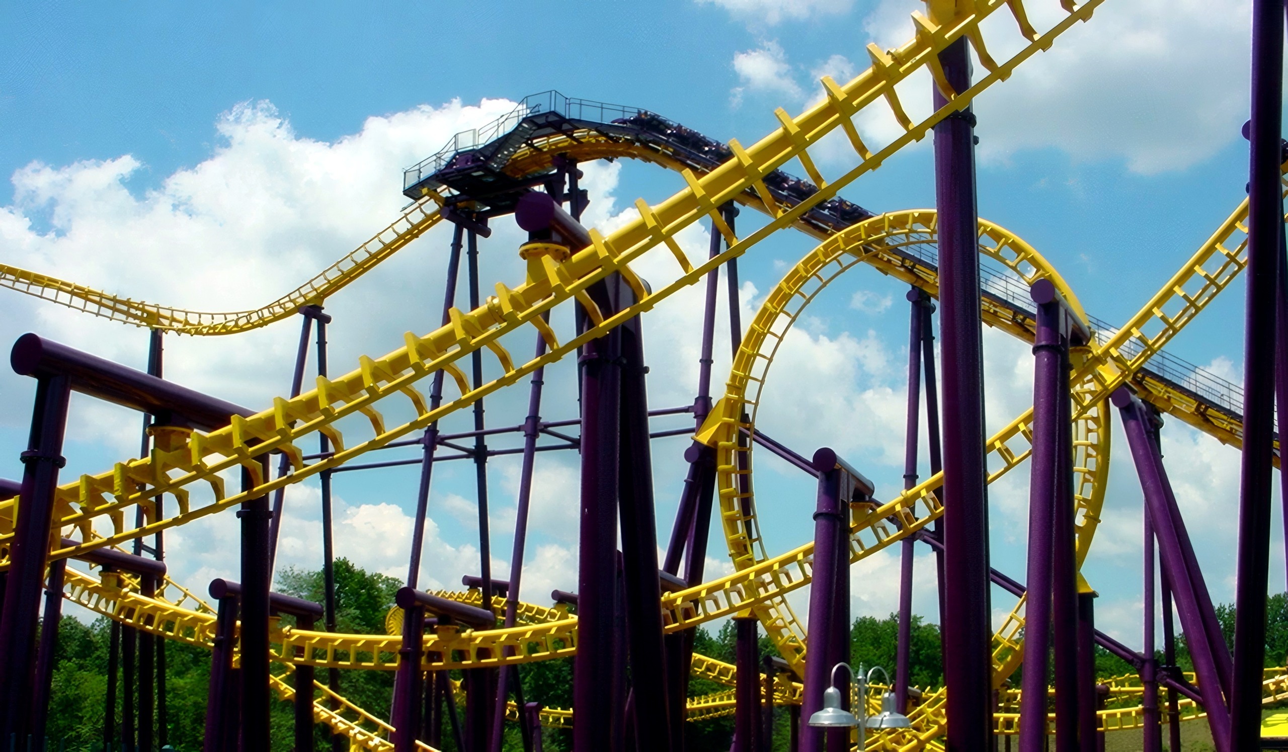 Batwing's tangle of yellow track and purple supports from the midway at Six Flags America, July 2001