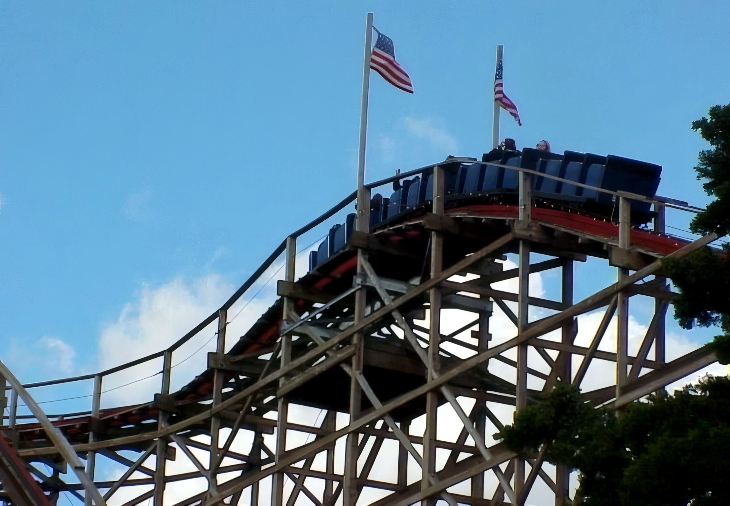 A Big Dipper train cresting the lift hill beneath the flags at Geauga Lake, May 2000