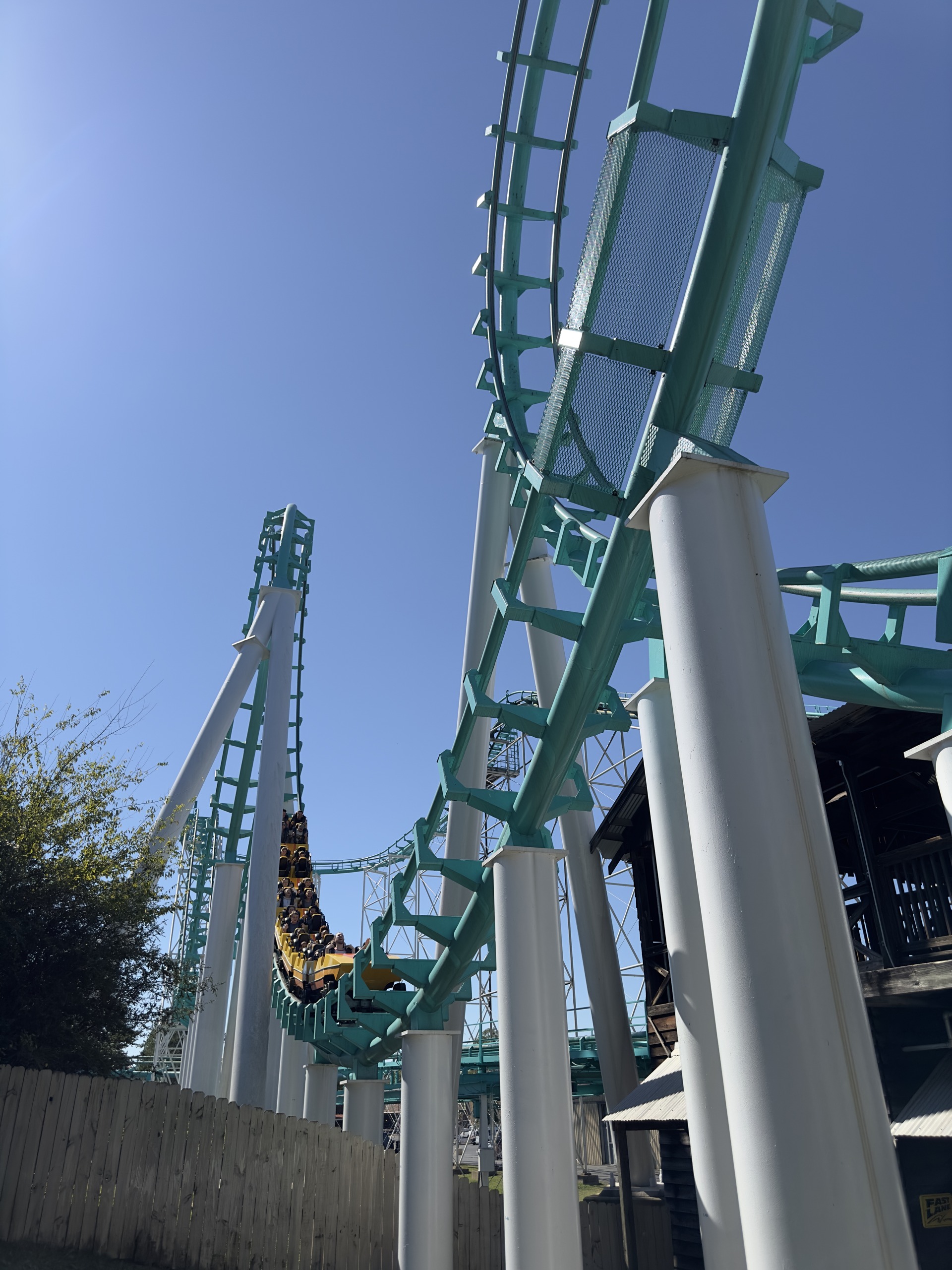 Looking up at Carolina Cyclone's loop and white supports with a train on the far side, Carowinds, October 2024